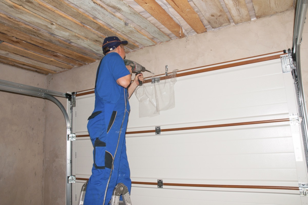 white man insulating garage door