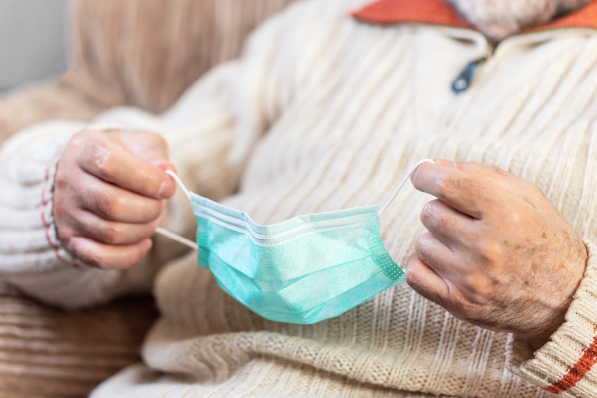 man holding onto face mask that may be too small