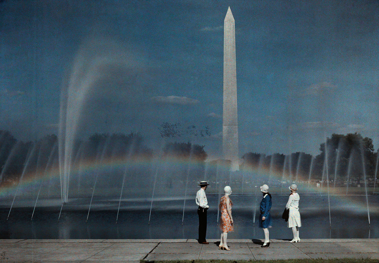 four people look at the washington monument in the 1930s