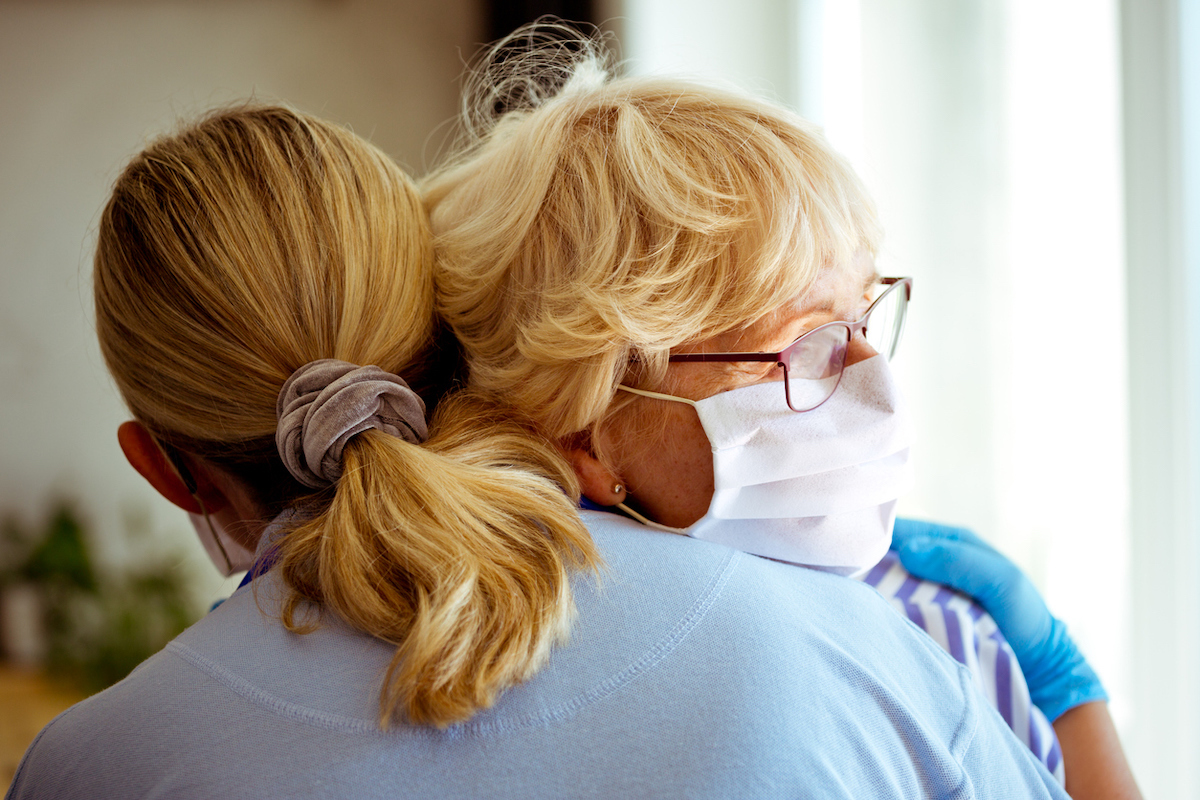 middle-aged woman embracing worried with senior woman