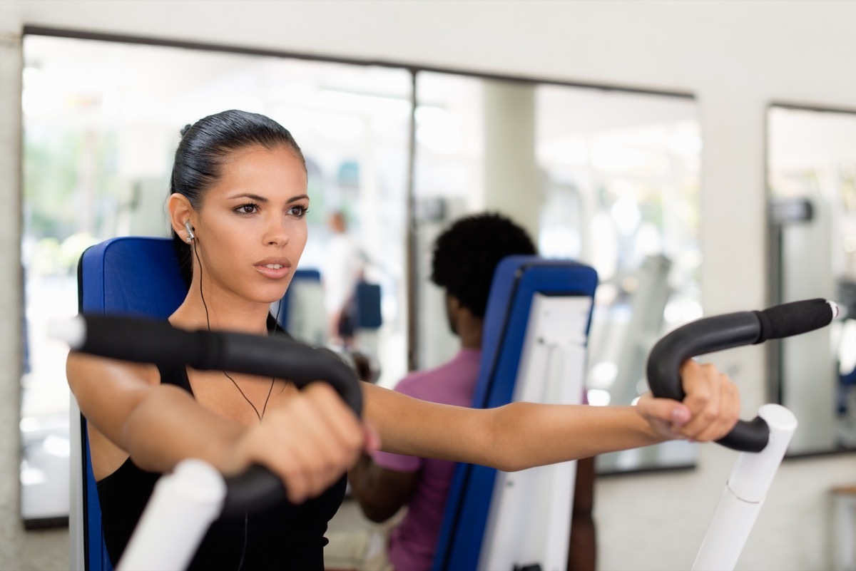 Younger woman working out on a machine at the gym