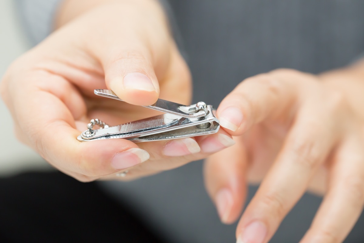 woman clipping her nails