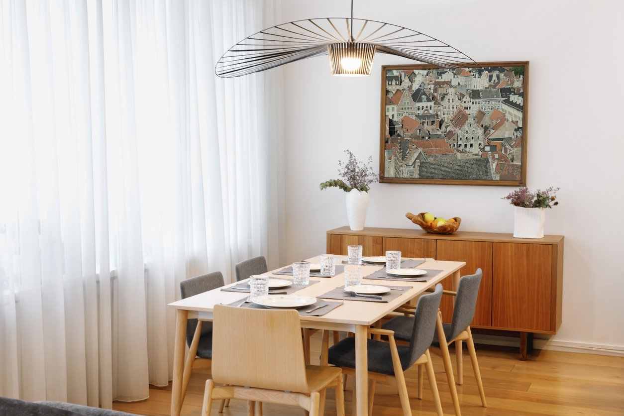 A dining room with a set table and artwork on the wall