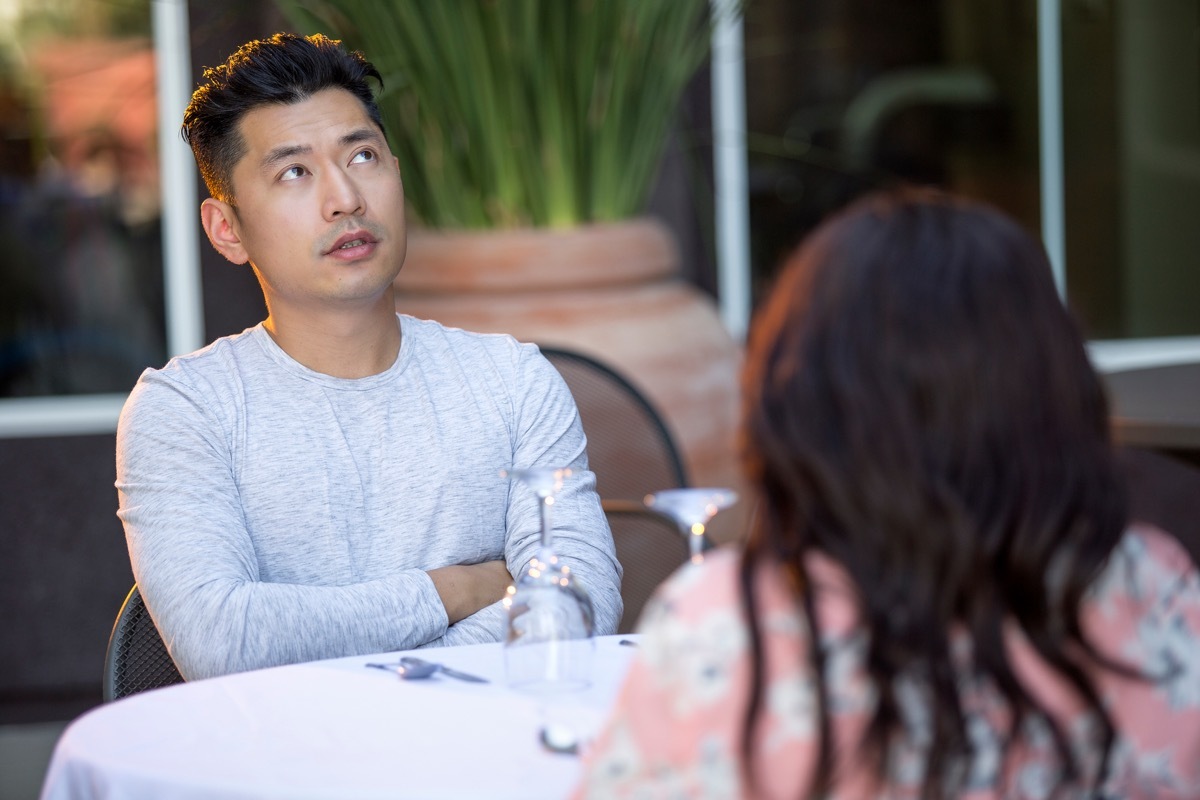 young asian man bored at dinner