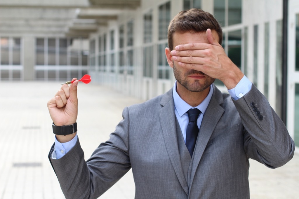 Coworker throwing darts with his eyes closed.