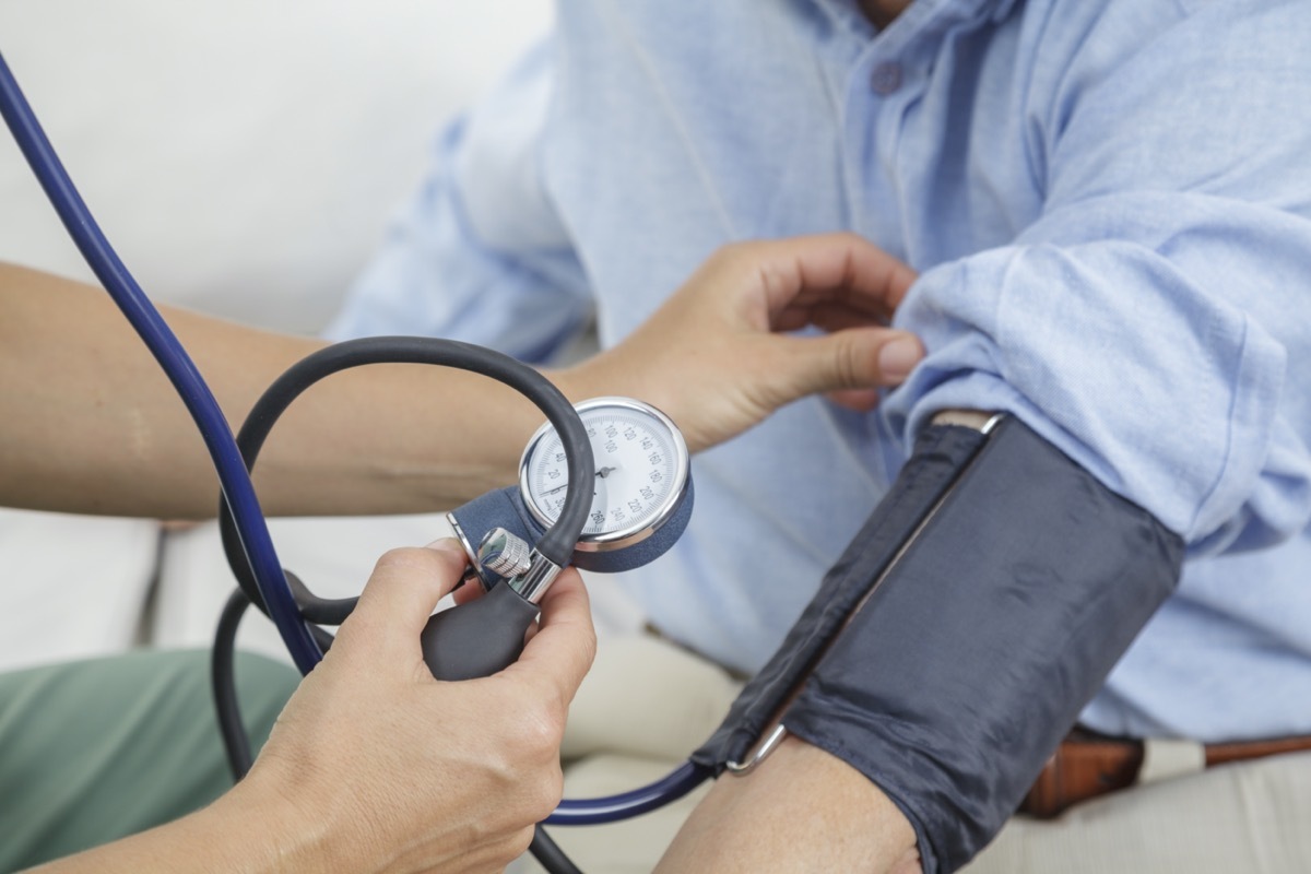 Nurse taking the blood pressure of elderly man