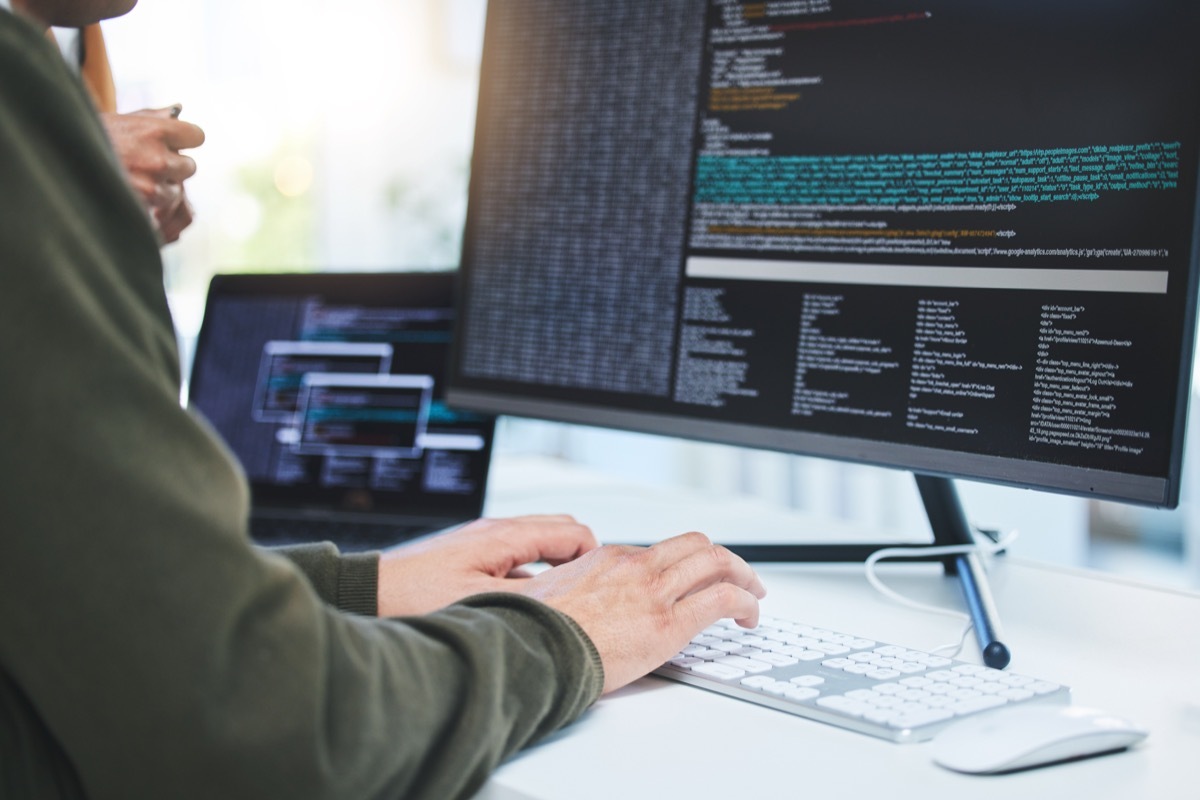 Programming, developer and hands on computer for coding, software script or cyber security in office. Closeup of IT technician person with technology for typing code, future and data analytics