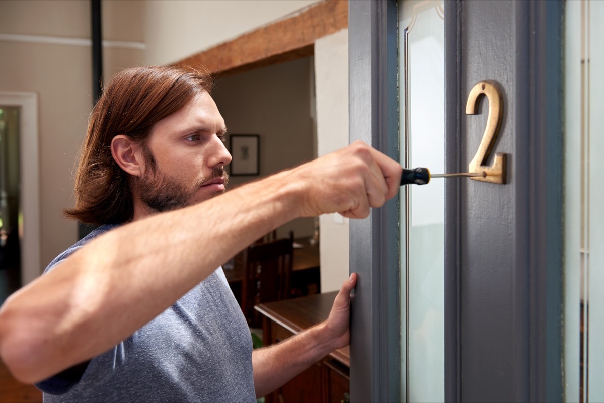 man fixing house numbers outside the home, fall home upgrades