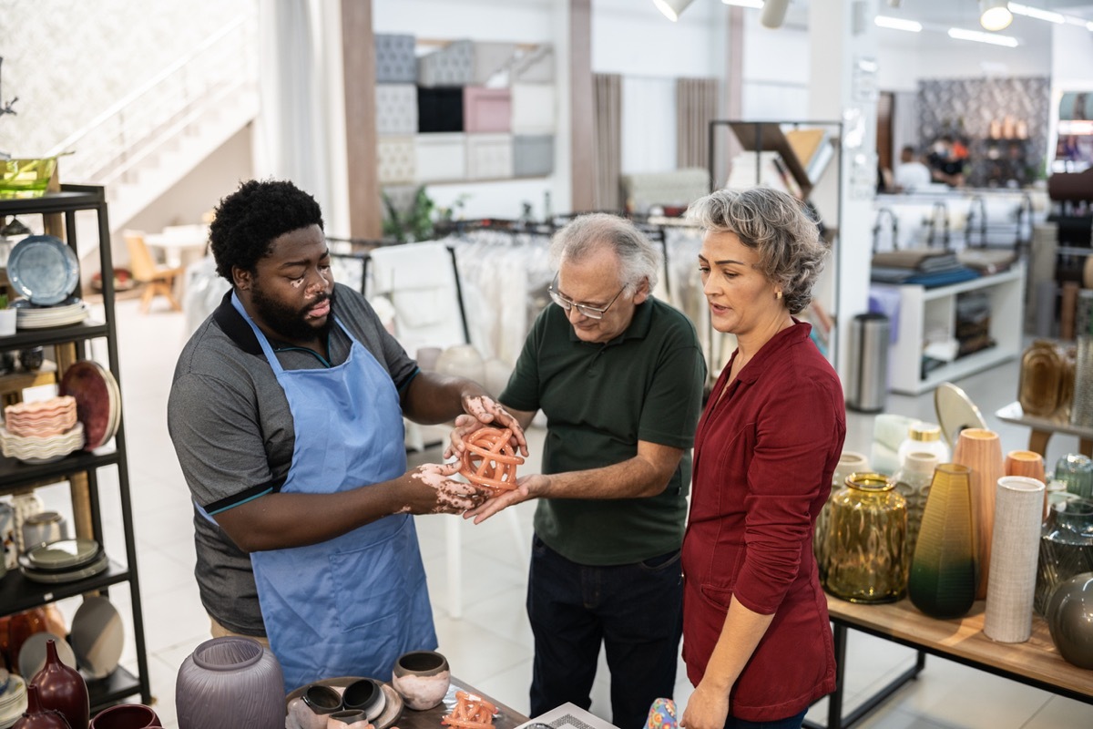 Salesman helping a couple at a decoration store