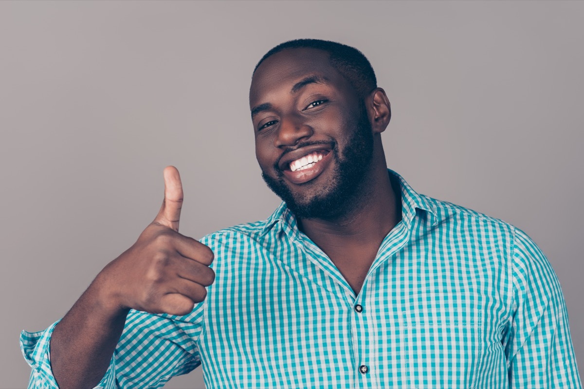 man laughing and showing thumb up gesture