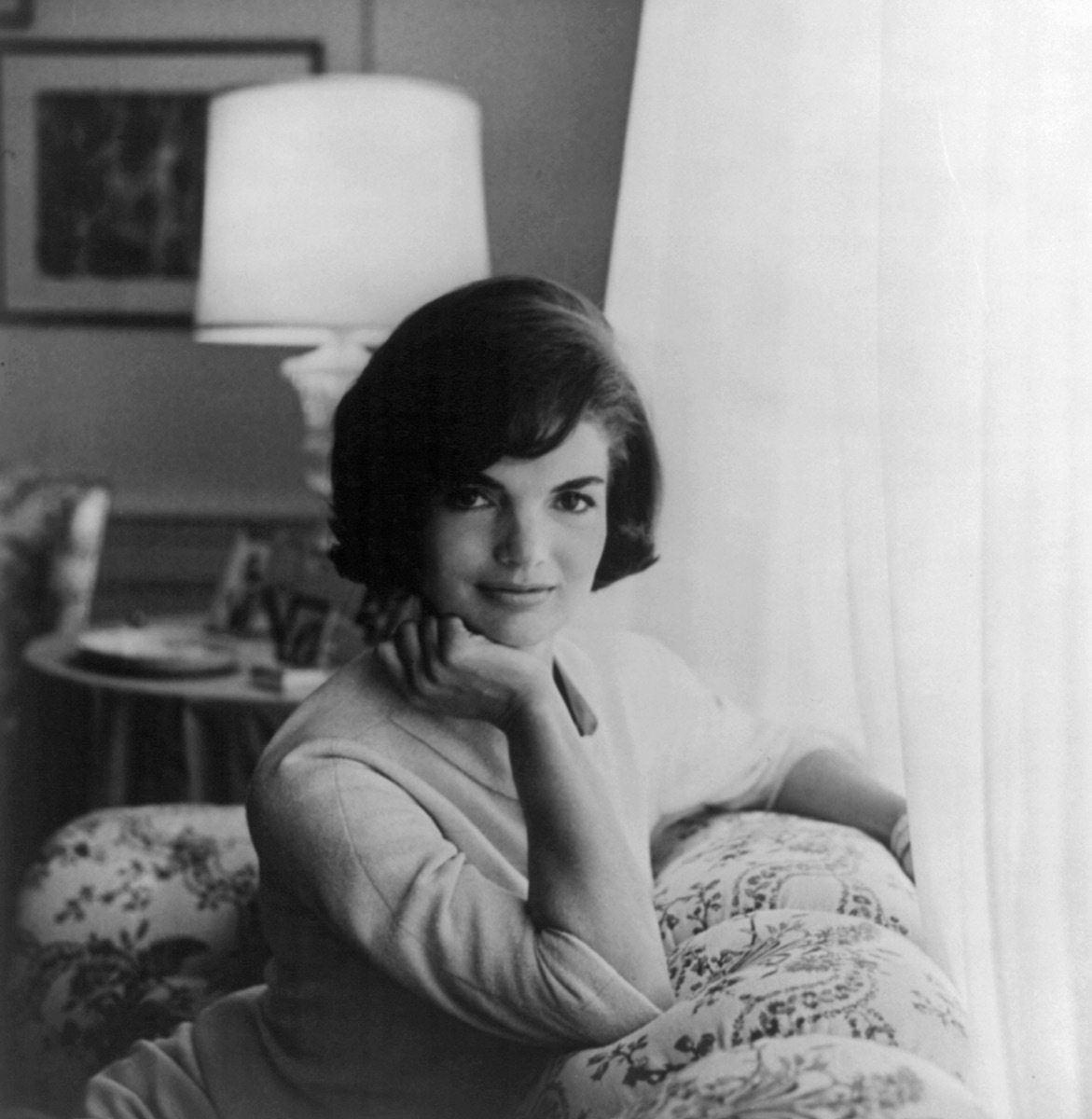 Portrait of Jackie Kennedy, Jacqueline Kennedy Onassis with hand on chin, leaning on couch