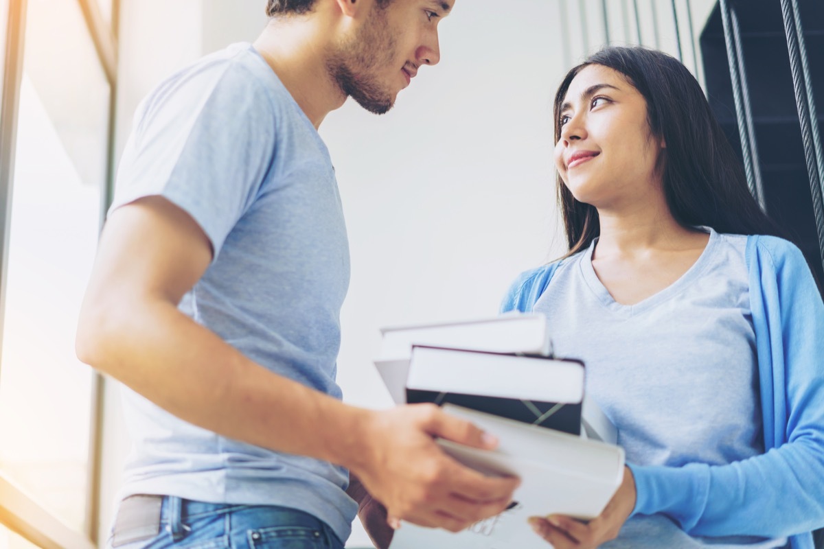 couple making eye contact while holding books