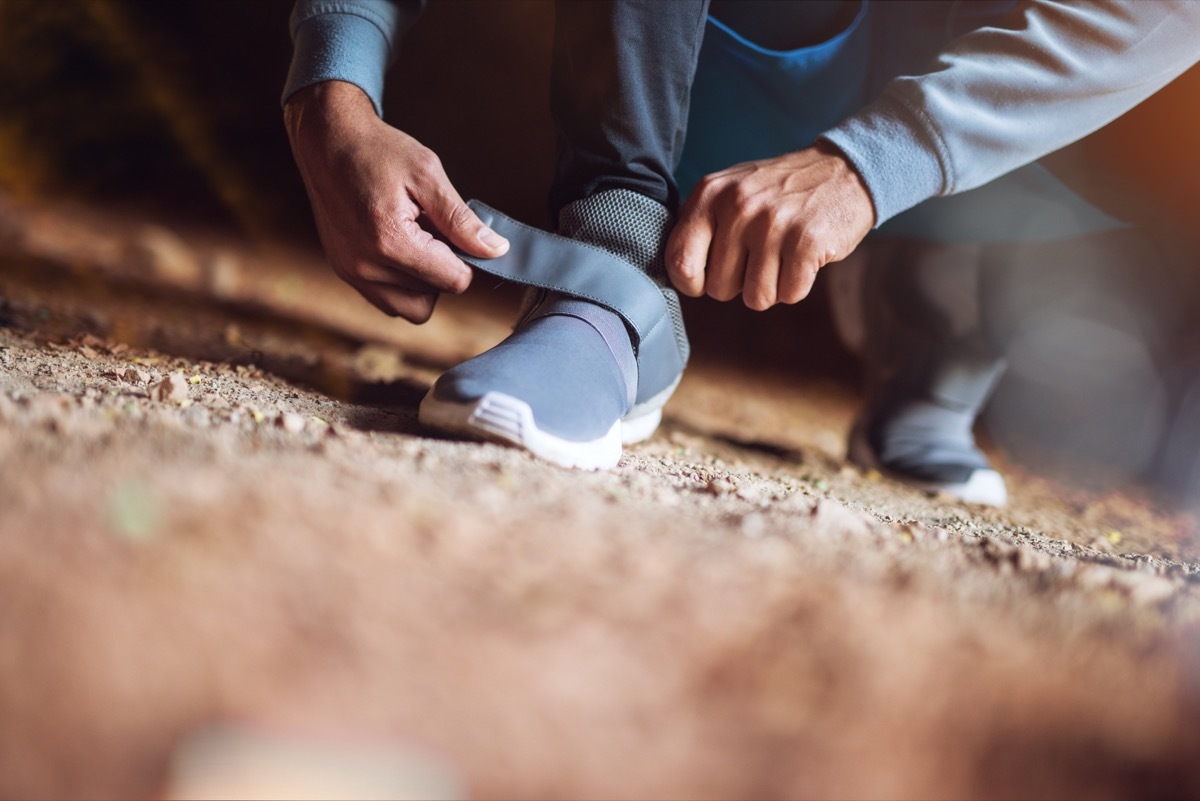 Man adjusting velcro exercise sneakers before his run